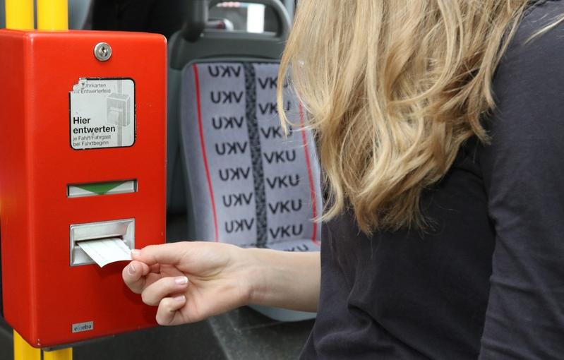 Eine Frau entwertet ein Ticket im Bus.