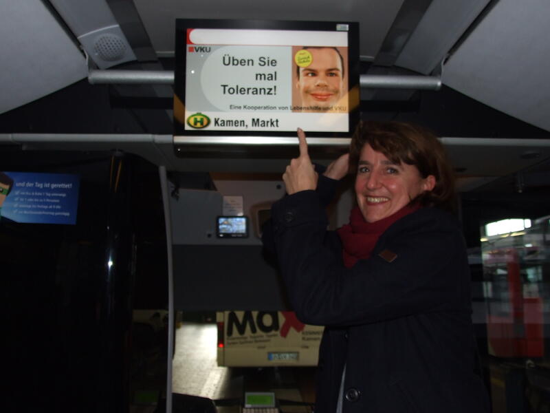 Eine Frau zeigt auf ein Schild mit der Aufschrift: "Üben Sie mal Toleranz!"
