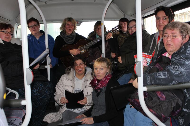 Eine Gruppe Menschen, die im Bus Musik macht.